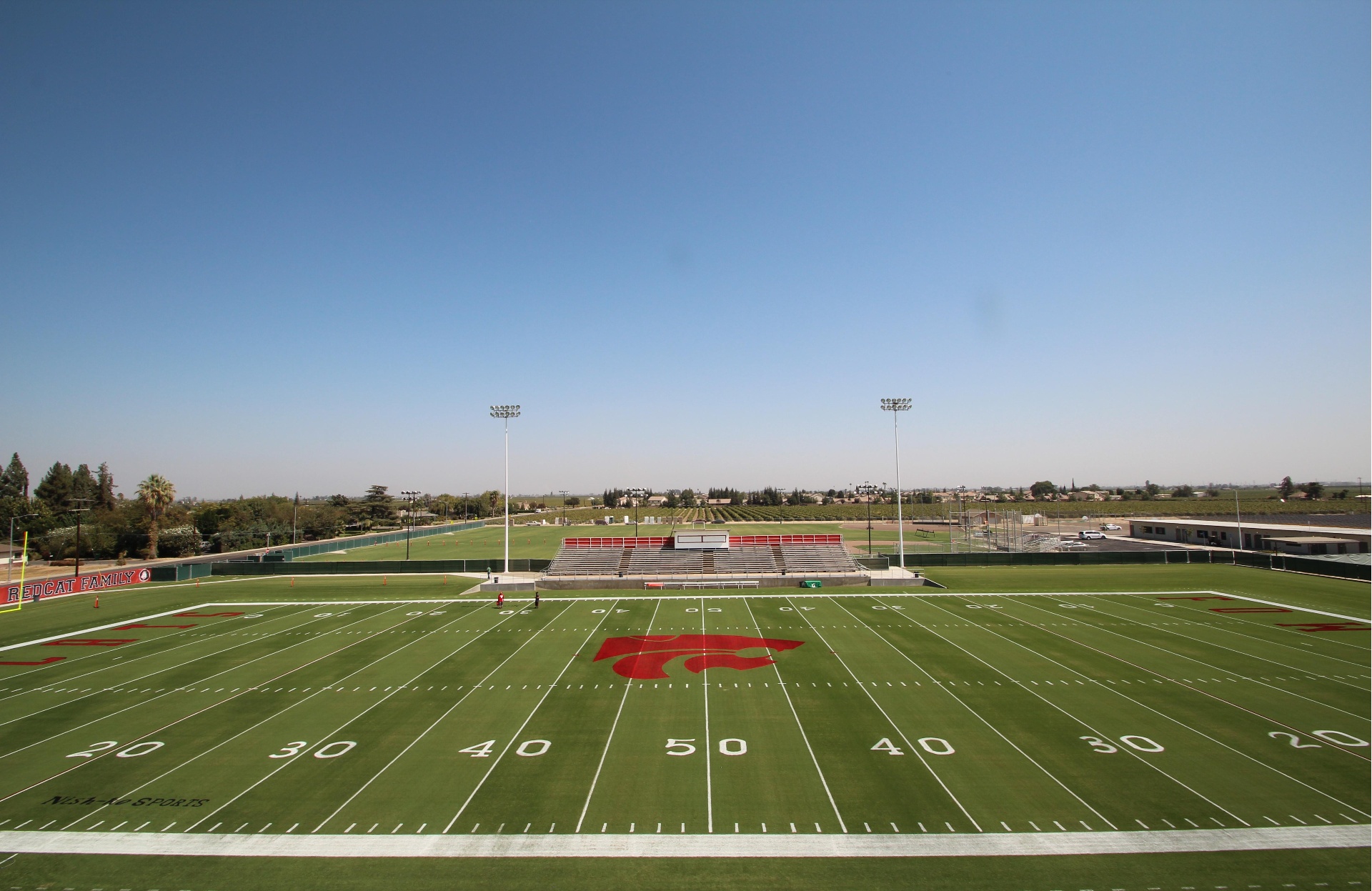 Painted high school football field with Redcats logo